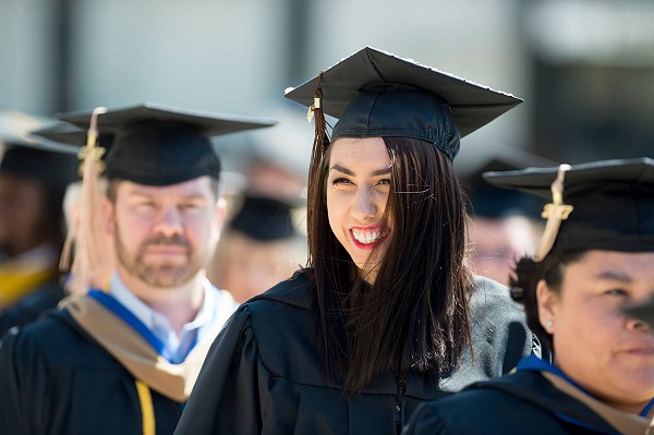 A Lakeland University student at graduation smiling.