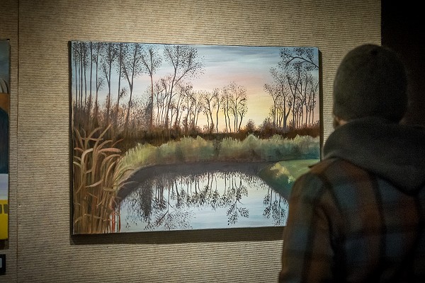 A Lakeland University student views a painting at a student art show