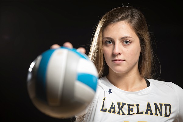 Lakeland women's volleyball player posing with ball.