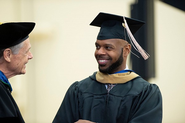 Lakeland University graduate shakes hand with Lakeland president.